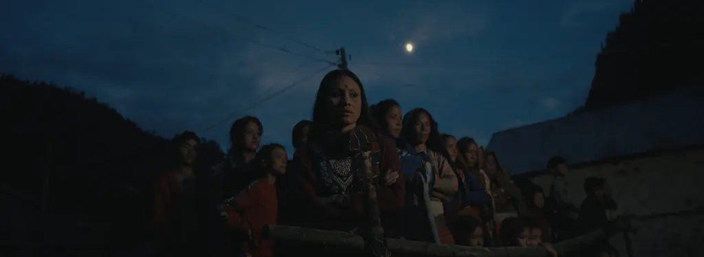Villagers gathered at night under a full moon