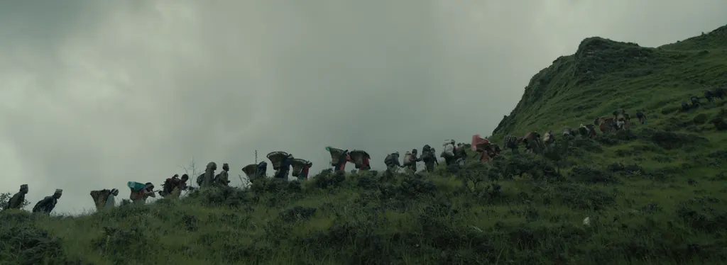 A line of porters silhouetted along a ridge