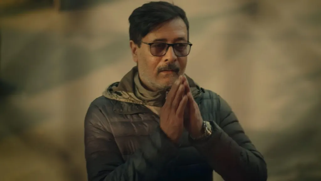A man in glasses greeting with folded hands