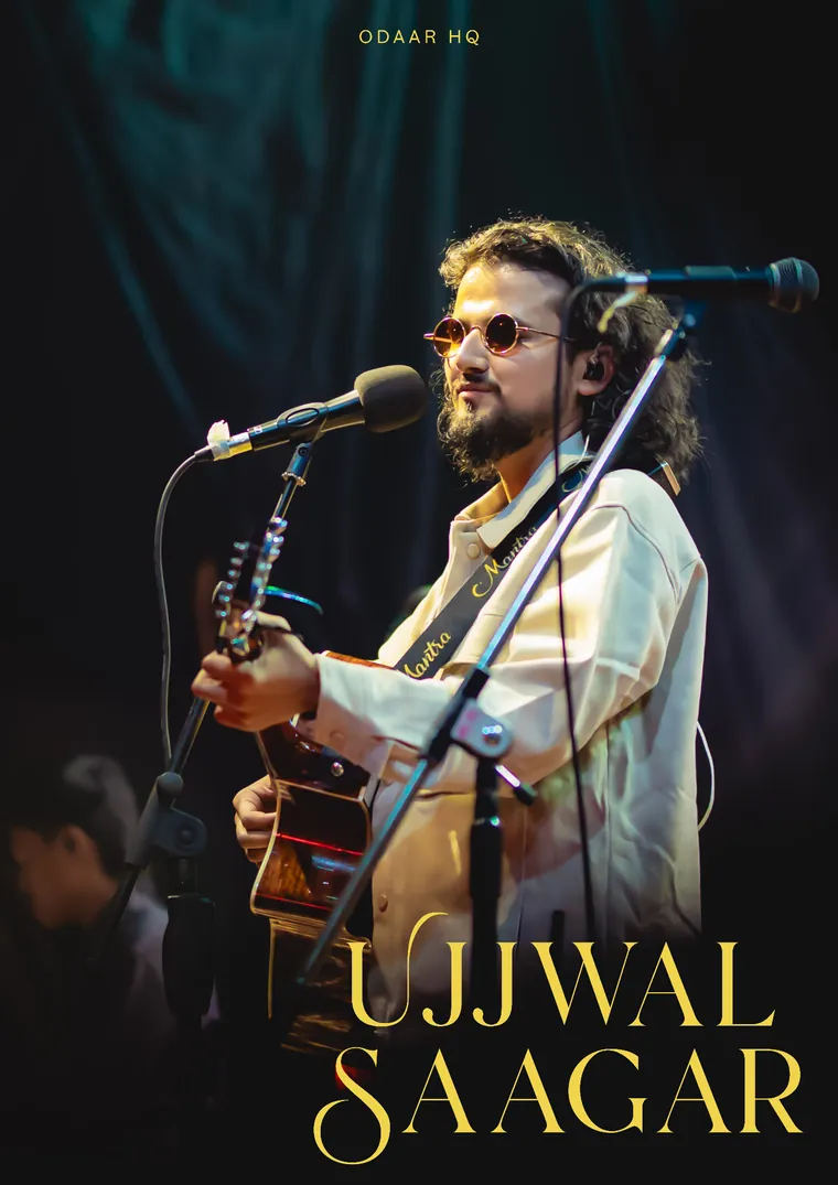 Ujjwal Saagar on stage with an acoustic guitar, singing into a microphone
